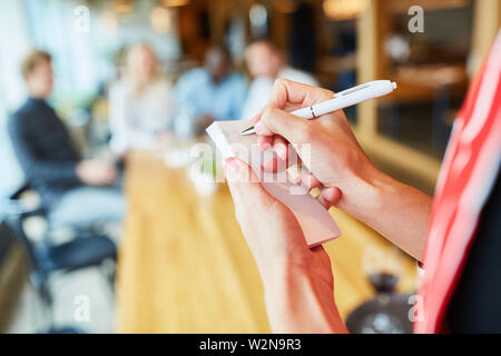 Waiter or waitress with notepad takes an order in the restaurant Stock Photo
