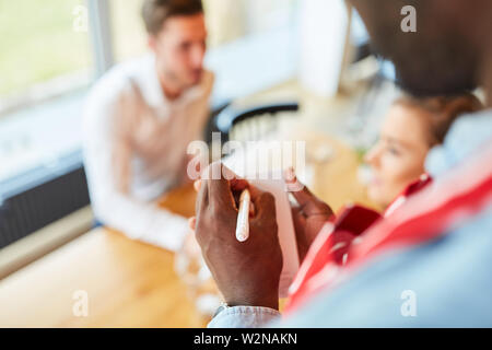Waiter or waitress notes the guests order on a notepad Stock Photo