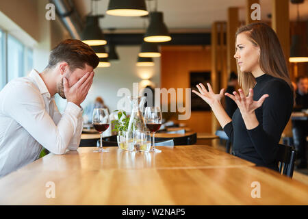 Young couple arguing and discussing in the restaurant over a glass of wine Stock Photo