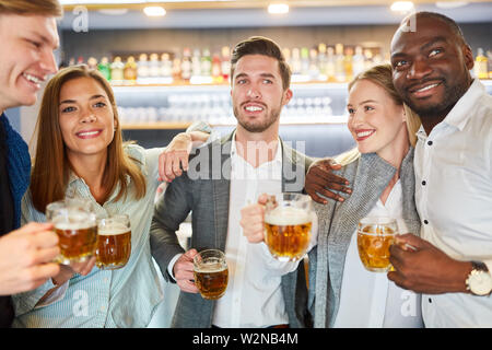 Group of friends having beer together in pub or bar after work Stock Photo