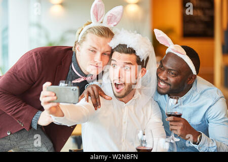 Friends celebrate bachelorette party and make a funny selfie together in a bar Stock Photo