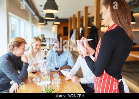 Waitress with notepad in the restaurant waits for the order of the guests Stock Photo