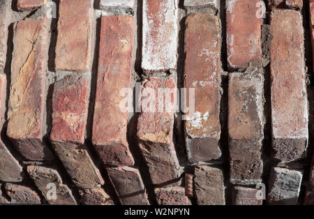 Abstraction The texture of the natural old corner of a brick wall red colored background. Stock Photo