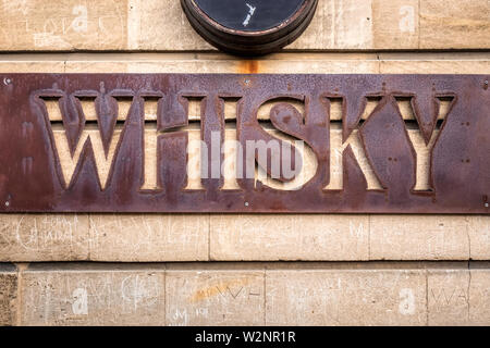 Old rusty whiskey sign at Oamaru in the South Island of New Zealand. Omaru is home to the steam punk. Stock Photo