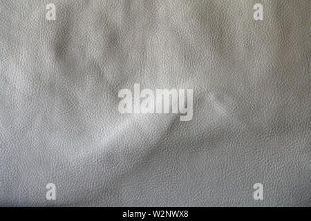 Closeup photo of an old white leather coach. In this photo you can see wrinkled, aged retro leather surface from a really close distance. Stock Photo