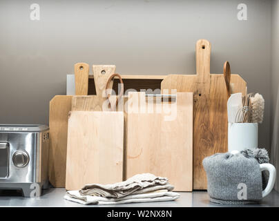 Collection of Chopping Boards on Metal Kitchen Counter with Teapot and Toaster Stock Photo