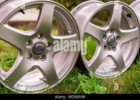 two Old original aluminum Volvo wheels. Used, outdoors, on green grass Stock Photo