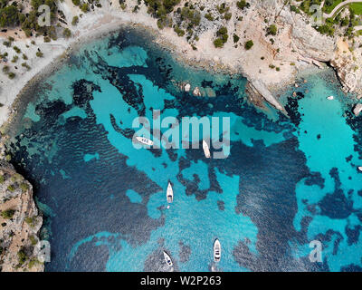 Drone point of view directly from above moored yachts on the bright blue bay on the Cala Blanca Andratx in the Palma de Mallorca, Spain Stock Photo