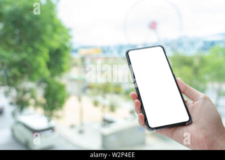 Mockup image of Woman hand holding mobile smartphones isolated white screen for mockup design and others app display background. Graphic design montag Stock Photo