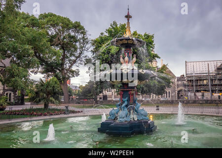 The restored Peacock Fountain in Christchurch Botanic Gardens at twilight with the Arts Centre (former University) in the background. Stock Photo