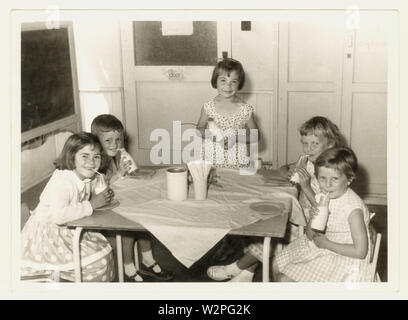 Original mid century, 1960's photograph of happy primary school children drinking free school milk from a bottle , possibly Leicestershire, U.K. Stock Photo