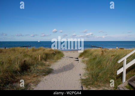 Beach at the baltic sea. Sandy beach path through the dunes to the sea. Blue sea and sky in the Background. People at the beach Stock Photo
