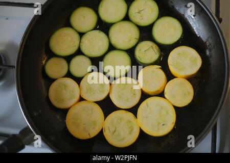 Yellow and green zucchini, sliced in the form of circles in a pan Stock Photo