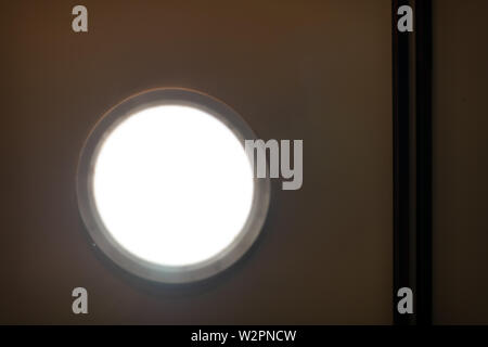 Abstract closeup of modern small skylight in room bathroom with white light on ceiling Stock Photo