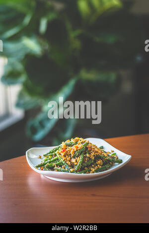 stir fried long beans with chilli and salted fish served on a  white plate Stock Photo