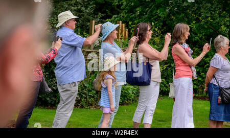 A line of people using their smartphones to snap Prince Charles, Patron of the Royal Botanic Gardens, Kew, during his visit to the Millennium Seed Bank at Wakehurst, West Sussex, in 2019. Stock Photo