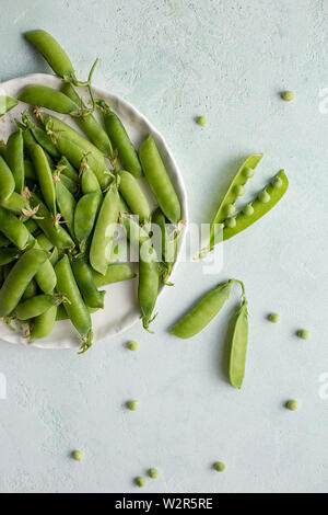 Green pea in white bowl. Copy space for text. Top view, flat lay. Concept of raw food Stock Photo