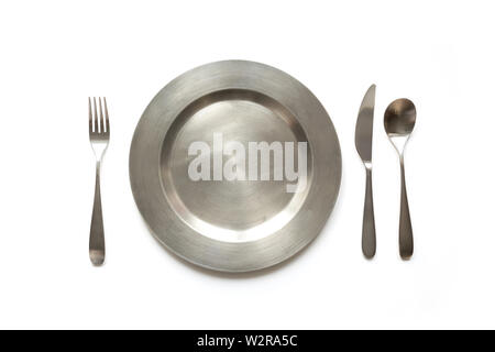 Empty metal dish with knife and fork on white background, with copy space. Table setting. Stock Photo