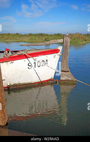 A wooden rudder fitted to the stern of an inshore boat moored in the harbour in North Norfolk at Blakeney, Norfolk, England, United Kingdom, Europe. Stock Photo