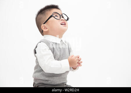 Cute Asian little boy wearing white shirt, grey vest and glasses isolated on white background. Creative ideas and innovation technology education conc Stock Photo