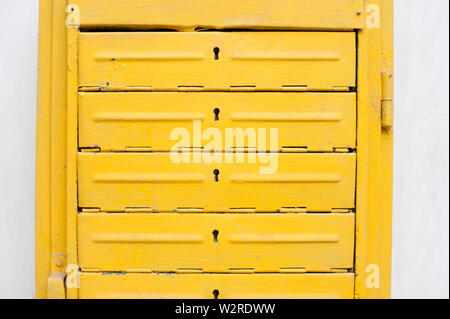 old vintage yellow iron letterbox on white wall Stock Photo