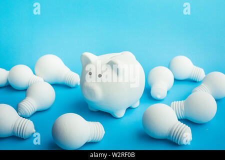 Saving money ideas concepts with  piggy bank and lightbulb on blue color background Stock Photo