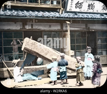 [ 1890s Japan - Japanese Carpenter and Children ] —   Children watch while a carpenter saws a huge log.  19th century vintage glass slide. Stock Photo