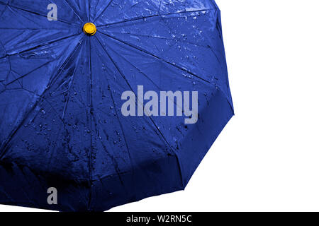 Wet blue umbrella close up image on isolated background. Waterproof fabric cloth with water drops and splashes. Good or bad weather concept. Rain in f Stock Photo