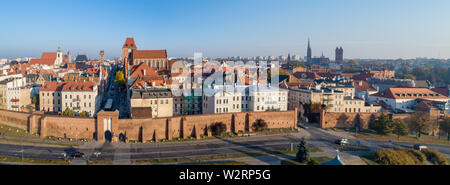 Wide aerial panorama of Torun Old City in Poland with Medieval Gothic Cathedral of St. John, town hall clock tower, churches, defensive wall and city Stock Photo