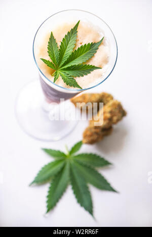 Nug Isolated Detail of cold glass of beer with cannabis leaf and nugs isolated over ...