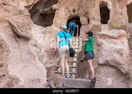Los Alamos, USA - June 17, 2019: Group of people tourists climbing ladder on Main Loop trail path in Bandelier National Monument in New Mexico during Stock Photo