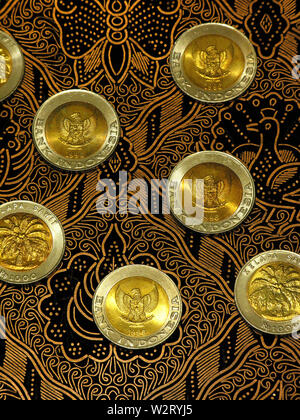 mettmann, germany - august 13, 2005: 1,000 indonesian rupiah coins on a batik stamp Stock Photo