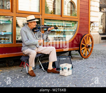 Bucharest, Romania - August 13th, 2018: A violinist plays music on one of the main streets of Bucharest, Romania Stock Photo