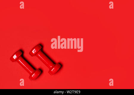 Top view of red dumbbells for fitness on red background. Stock Photo