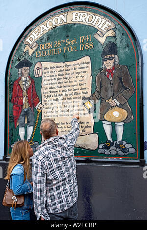 Tourists read the sign on the wall of Deacon Brodie s Tavern in the