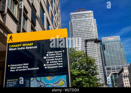 Canary Wharf pedestrian walkway walking directions sign in West India Avenue, directing to Cabot Square, Canada Square, Crossrail Place, Fisherman's Walk, West India Quay and Museum of London Docklands. Iconic One Canada Square and Citi Bank towers behind Canary Wharf London E14 Stock Photo