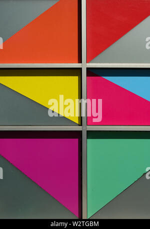 Bright colorful angled shapes in windows on the side of a building Stock Photo
