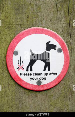 A sign asking dog walkers to clean up after their dogs. Stock Photo