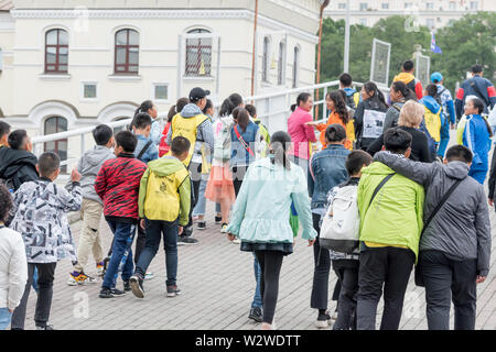Russia, Vladivostok, 07/06/2019. Group of kids tourists from South Korea walking in city downtown. Tourism in Vladivostok, asian schoolchilds and kids Stock Photo