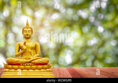 Golden Buddha image under the Bodhi leaf, natural background Stock Photo