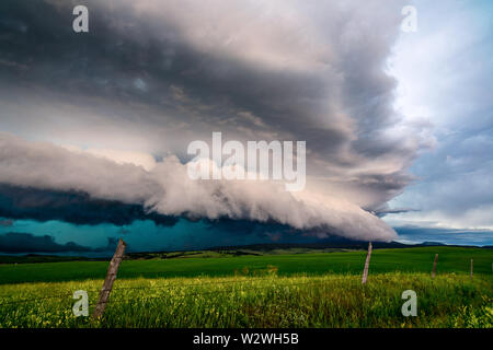 A thunderstorm with dramatic, dark clouds over a field near Lewistown, Montana, USA.