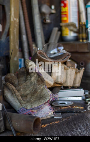 Pile of tools, scraps and gears on a work bench Stock Photo