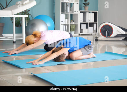 Physiotherapist working with little boy in rehabilitation center Stock Photo