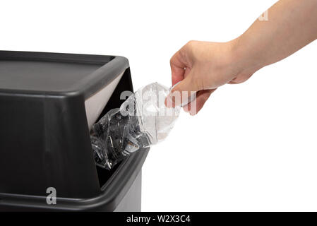 The hand of a man who throws a plastic bottle into a trash can. waste ...