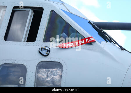 Remove before flight safety warning ribbon on the windscreen of a military cargo plane Stock Photo