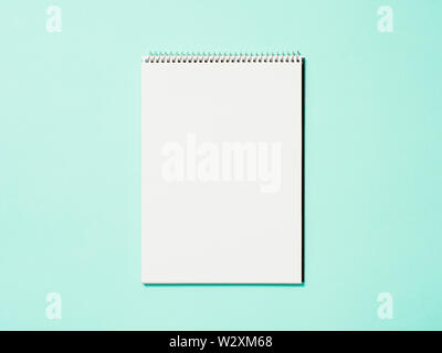 Blank paper notebook. Empty paper sketchbook on blue background. Top view or flat lay. Copy space for text or design. Stock Photo