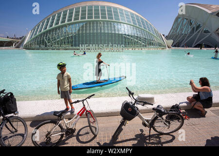 Valencia, Spain. 10th June, 2019. People enjoy on the lake in front of Hemisferic cinema at the arts & science city in Valencia.Arts and Science City is an entertainment-based cultural, sci-fi-style and architectural complex in the city of Valencia, Spain. It is the most important modern tourist destination in the city of Valencia. Designed by Santiago Calatrava and Félix Candela, the project began the first stages of construction in July 1996, and was inaugurated April 16, 1998 with the opening of L'HemisfÃ¨ric. The last great component of the City of Arts and Sciences, El Palau de les Arts Stock Photo