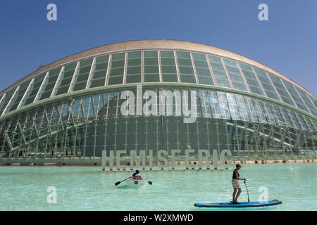 Valencia, Valencia, Spain. 10th June, 2019. People with boat and surfboard in the lake in front of the Hemisferic Cinema in Valencia.Arts and Science City is an entertainment-based cultural, sci-fi-style and architectural complex in the city of Valencia, Spain. It is the most important modern tourist destination in the city of Valencia. Designed by Santiago Calatrava and Félix Candela, the project began the first stages of construction in July 1996, and was inaugurated April 16, 1998 with the opening of L'HemisfÃ¨ric. The last great component of the City of Arts and Sciences, El Palau de les Stock Photo