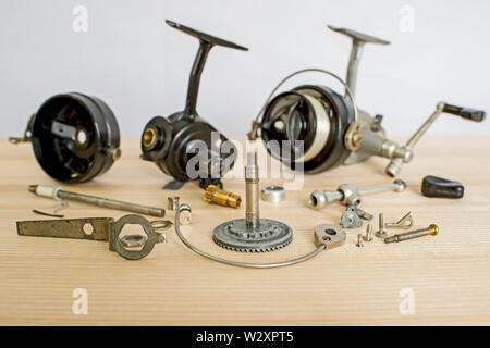 A fishing spinning reel as a whole and a second similar completely  disassembled. Concept: parts of a whole Stock Photo - Alamy