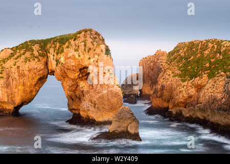 Bizarre elephant rock of castro de las gavioatas in golden light of the sunset at the coast of asturias, Northern Spain Stock Photo